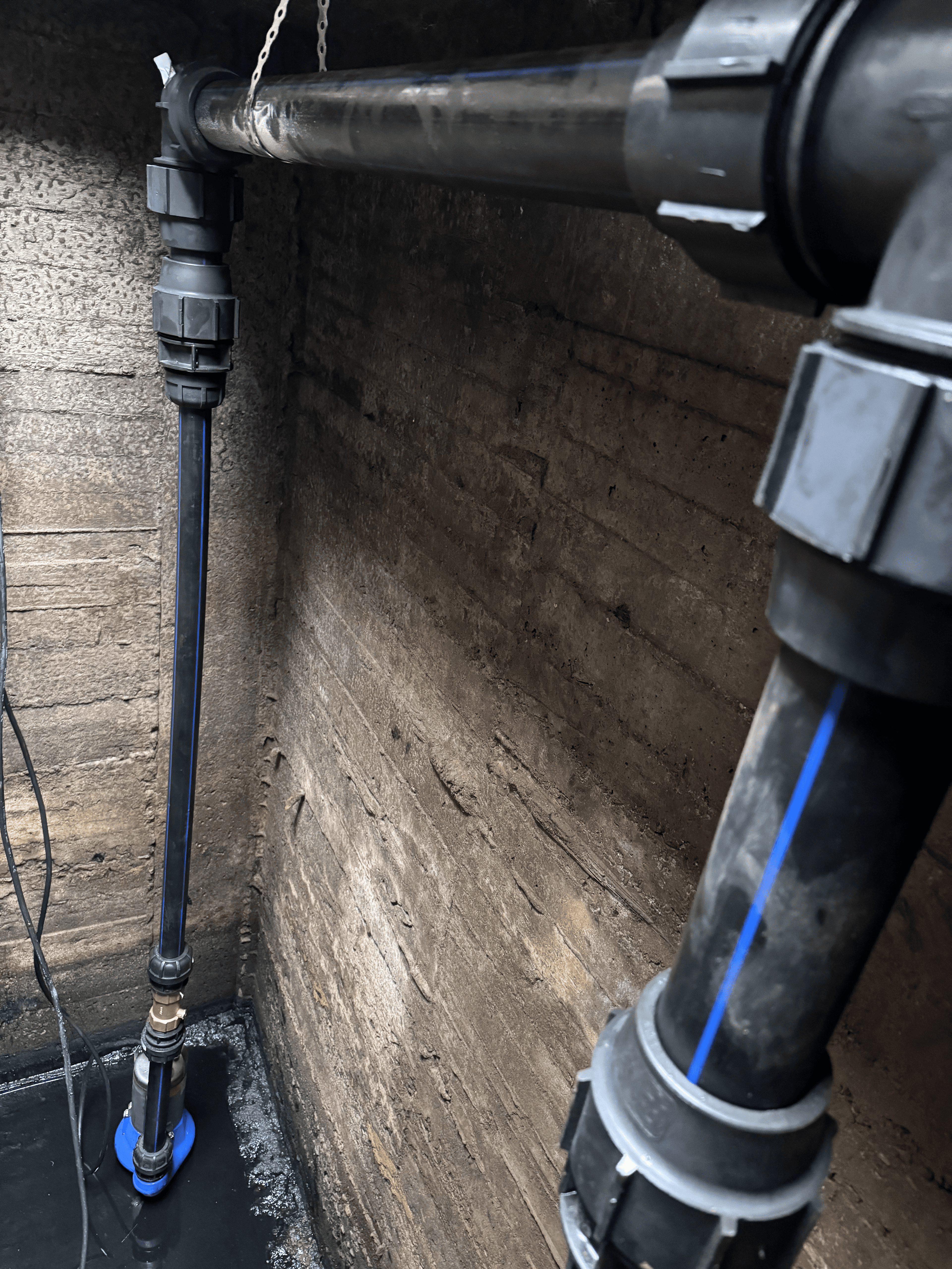 Brunnsinstallation med två nedsänkpumpar och avgänger i polyetenslang.